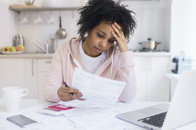 stressed woman looking at her electric bill