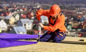 man installs a flat roof