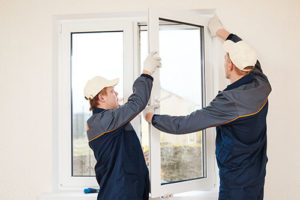 two men install a window in howard county 