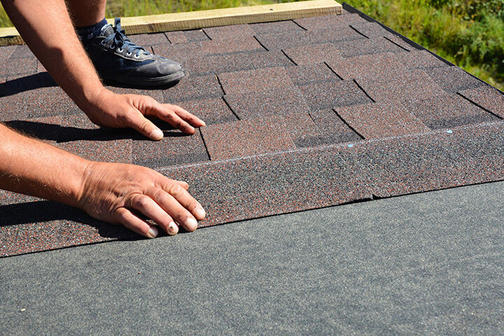 man laying shingles for new residential roof