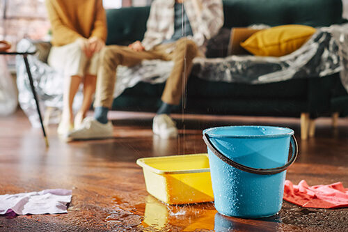 buckets on residental floor catching water from a roof leak