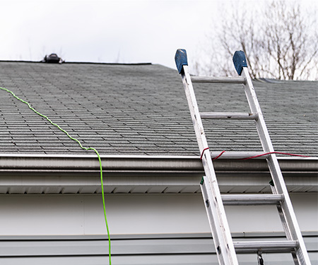 ladder leaning against house & leading up to roof