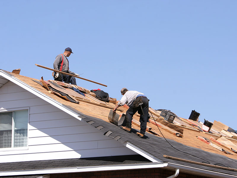 Two roofers installing a new residential shingle roof.