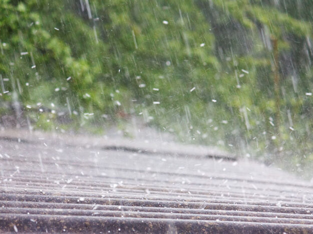 storm-roof-damage-maryland Heavy rain falling on a residential roof