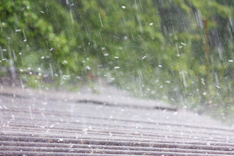 Heavy rain falling on a residential roof
