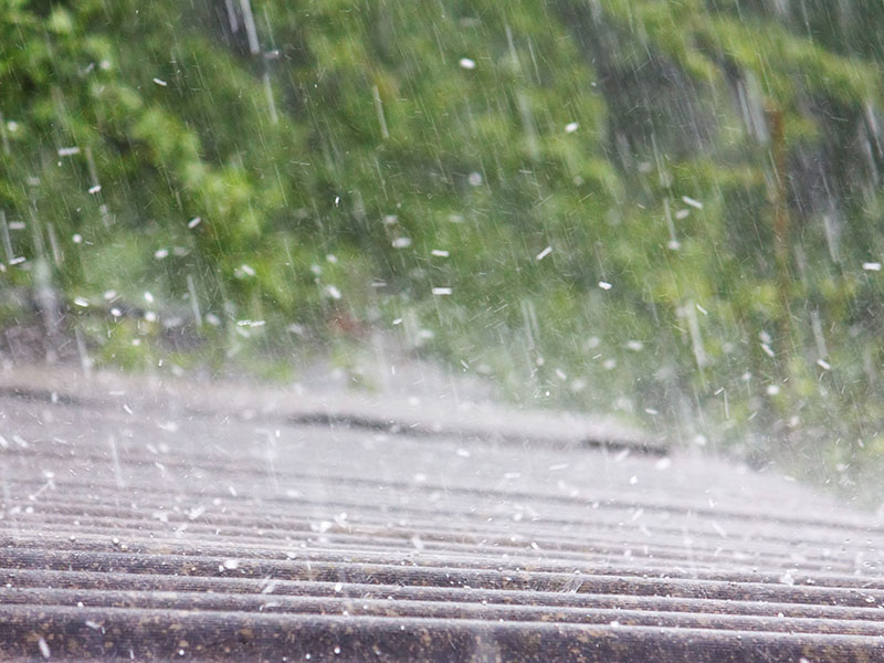 storm-roof-damage-maryland Heavy rain falling on a residential roof