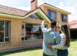 Homeowners looking up at roof.