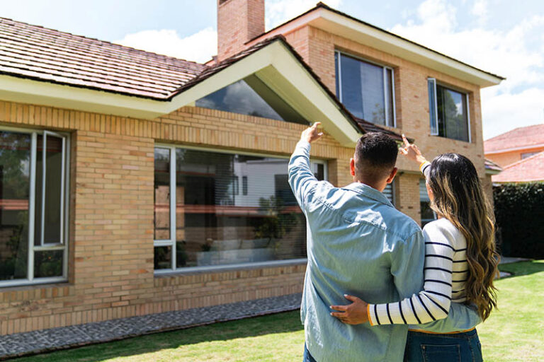 Homeowners looking up at roof.