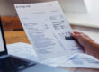 Man holding energy bill document.