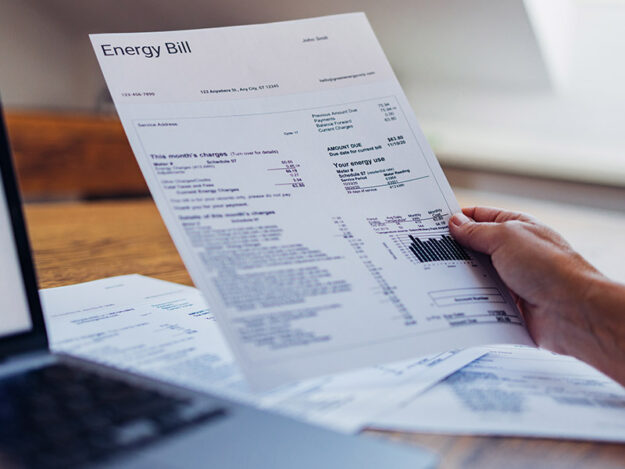Man holding energy bill document.