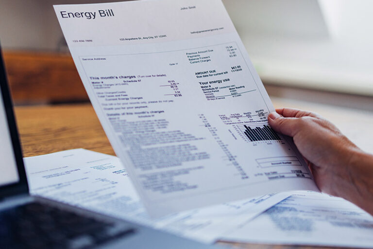 Man holding energy bill document.