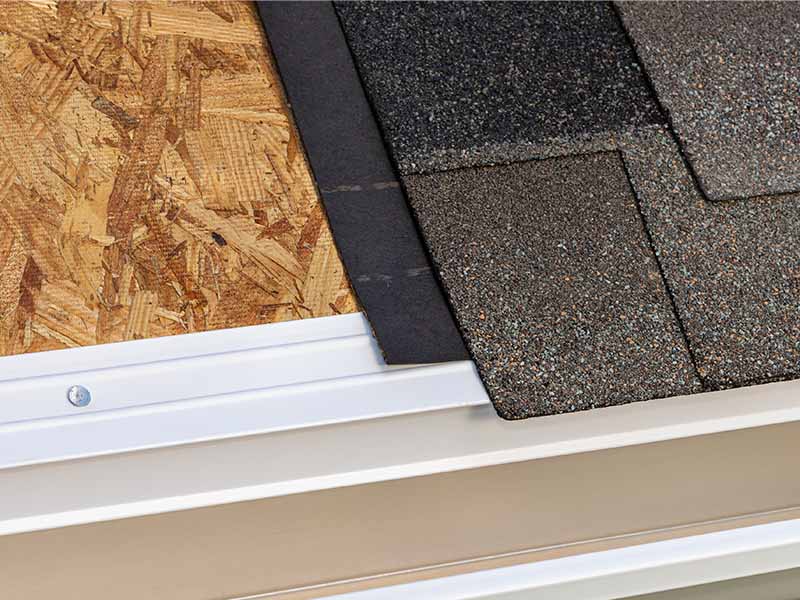 roofing-materials Partially deconstructed residential roof, showing roofing decking to the left and shingles to the right.