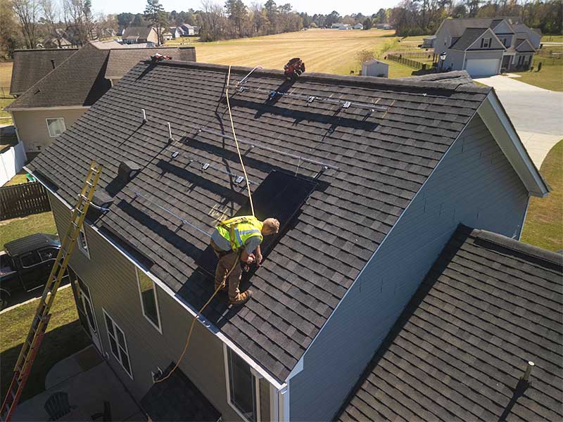 Roofer on a residential roof completing repairs.